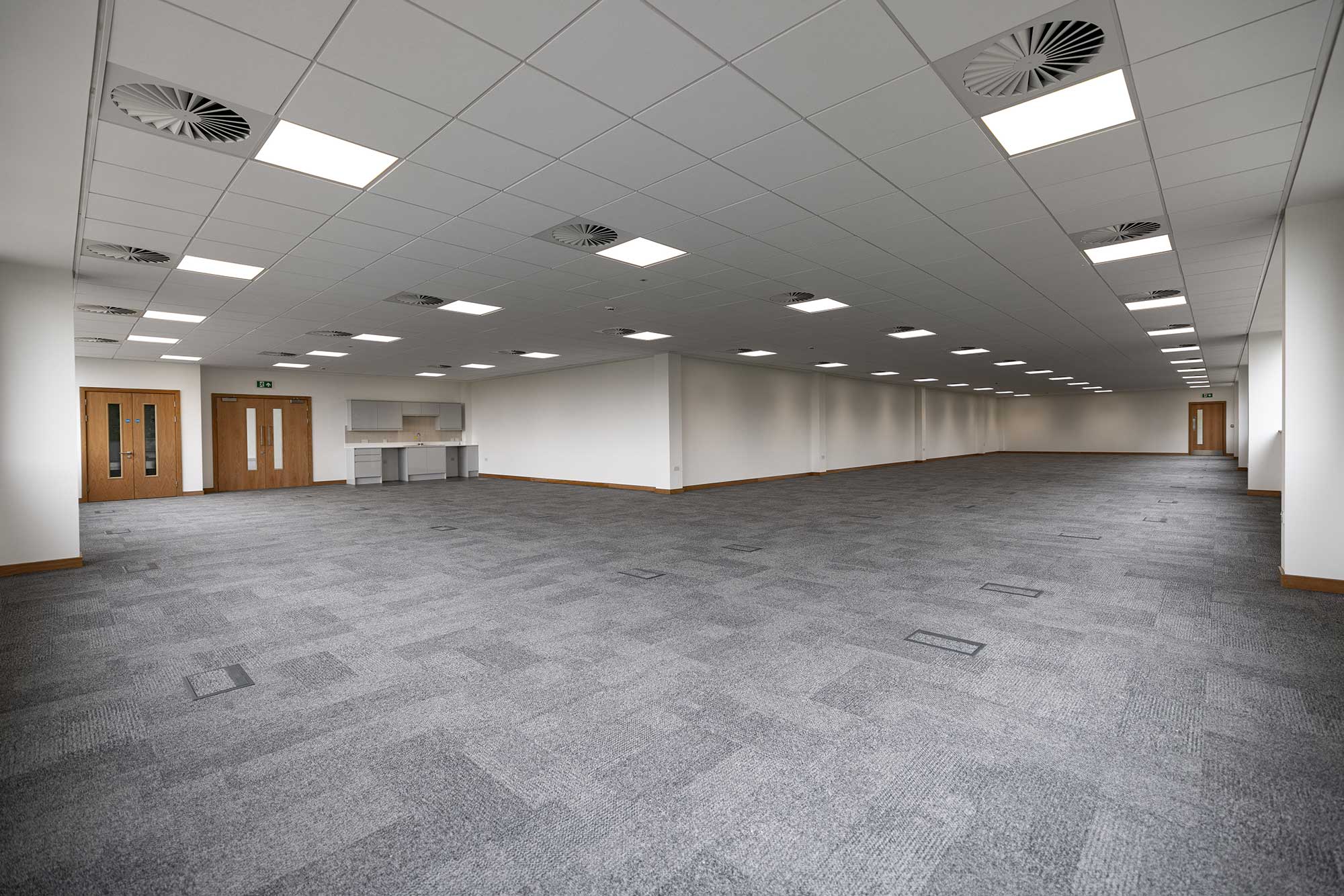 Fitted office floor with kitchenette and carpeted open plan space